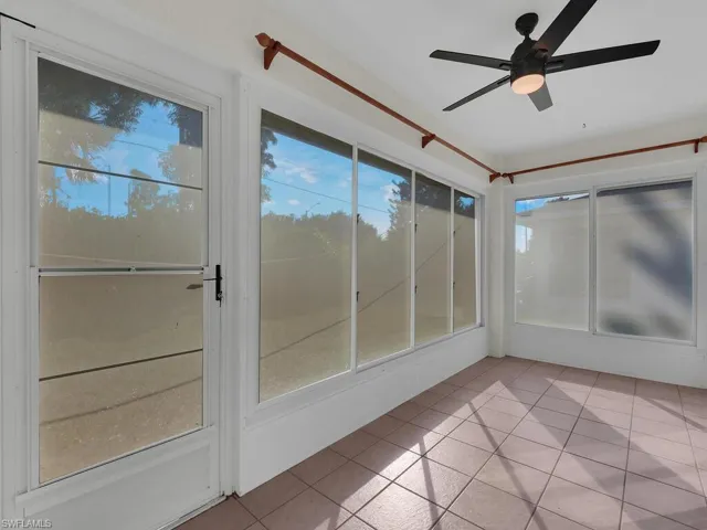 Unfurnished sunroom featuring a healthy amount of sunlight and ceiling fan