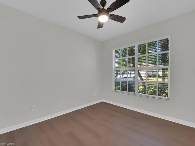 Spare room with dark hardwood / wood-style flooring and ceiling fan