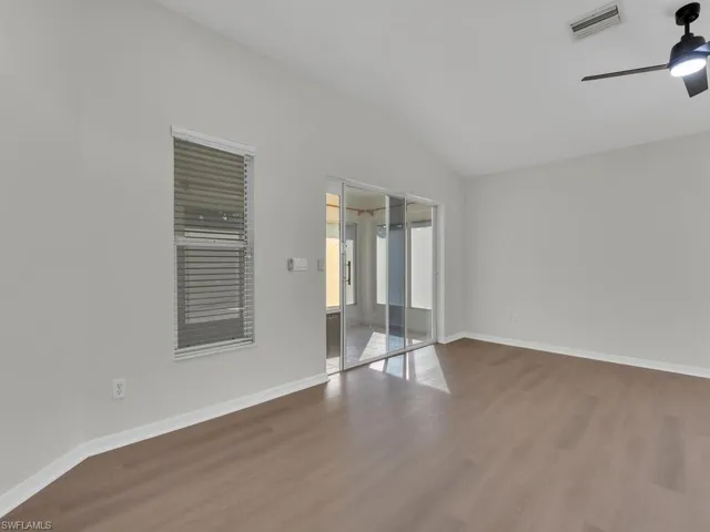 Spare room with ceiling fan, hardwood / wood-style flooring, and lofted ceiling