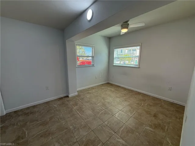 Spare room with baseboards and a ceiling fan
