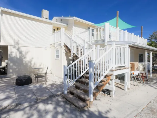 Rear view of house featuring an outdoor fire pit, stairs, a patio area, a deck, and a chimney