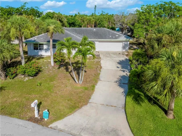 Ranch-style home with a garage and a front lawn