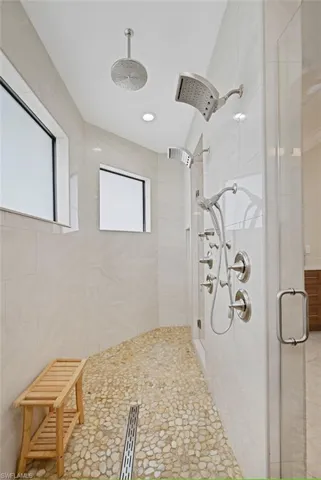 Bathroom with a shower with shower door and a wealth of natural light