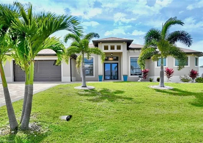 View of front of property featuring a garage and a front lawn