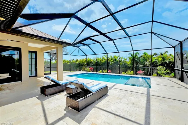 View of swimming pool with glass enclosure and a patio area