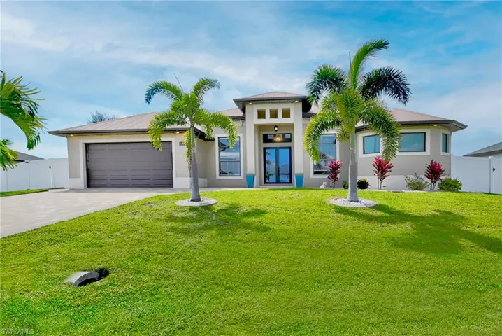 View of front of house featuring a front lawn and a garage