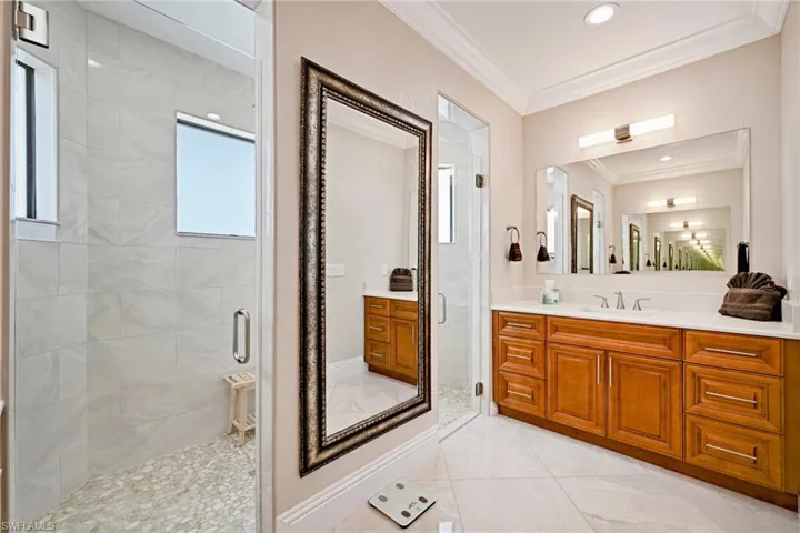 Bathroom featuring tile floors, a shower with door, a healthy amount of sunlight, and vanity