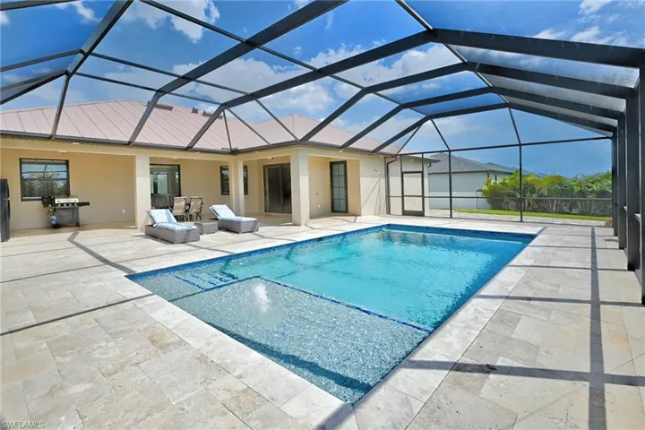 View of swimming pool with a patio area and glass enclosure