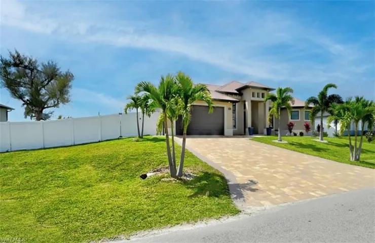 View of front of home with a garage and a front lawn