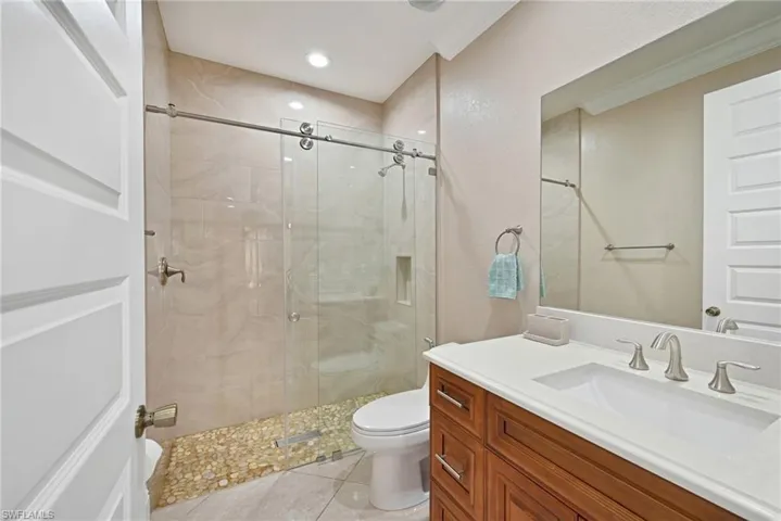Bathroom with crown molding, an enclosed shower, tile flooring, and toilet
