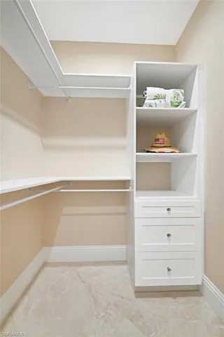 Walk in closet featuring light tile floors