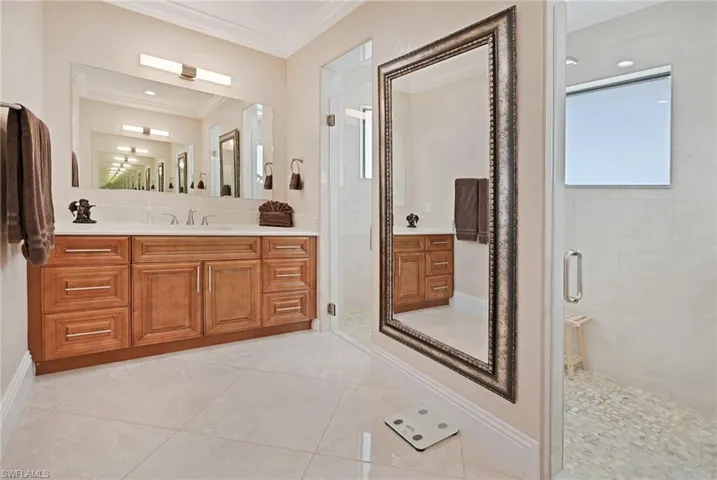 Bathroom with walk in shower, tile flooring, ornamental molding, and oversized vanity