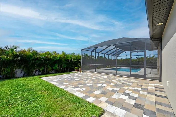 View of yard featuring glass enclosure and a patio area