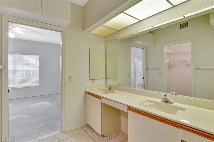 Bathroom featuring tile patterned floors, double sink vanity, and ceiling fan