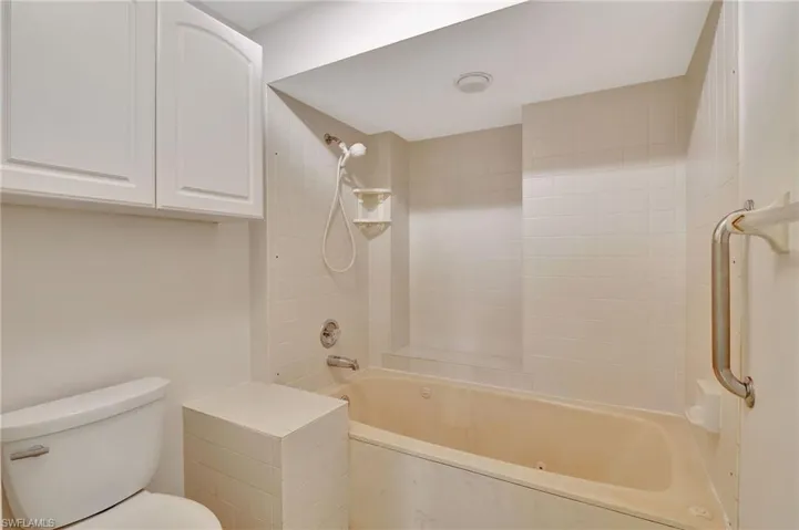 Bathroom featuring tiled shower / bath and toilet