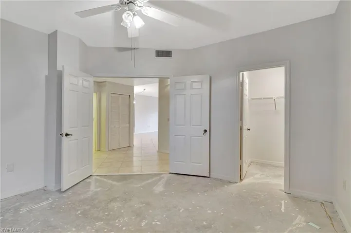 Unfurnished bedroom featuring a closet, a spacious closet, and ceiling fan