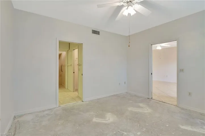 Unfurnished bedroom featuring ensuite bathroom, ceiling fan, and light tile patterned floors