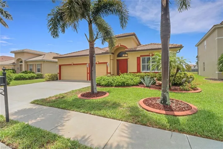 Mediterranean / spanish-style home with an attached garage, stucco siding, a tiled roof, driveway, and a front yard