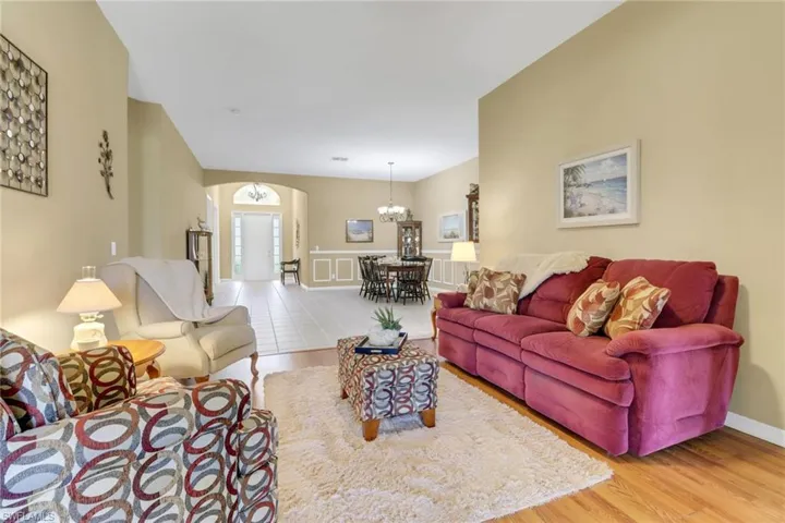 Living room featuring a chandelier, wood finished floors, and arched walkways