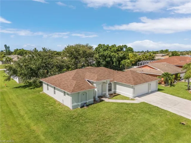 View of front of house featuring a garage and a front lawn