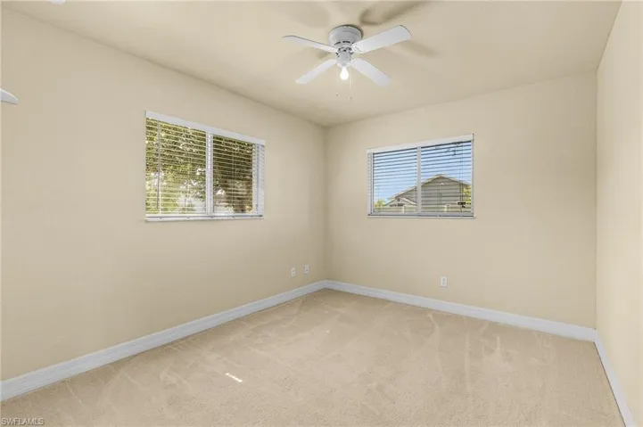 Carpeted spare room featuring ceiling fan