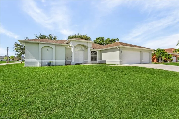 View of front of home with a garage and a front lawn