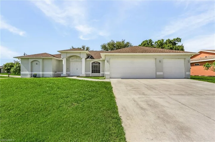 View of front facade featuring a garage and a front yard
