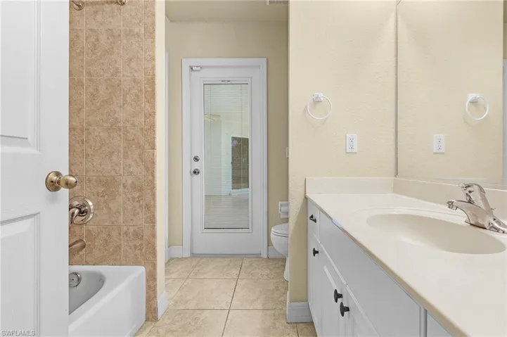 Full bathroom with vanity, tile patterned floors,  shower combination, and toilet