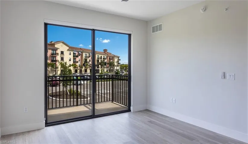 Unfurnished room featuring visible vents, baseboards, and wood finished floors