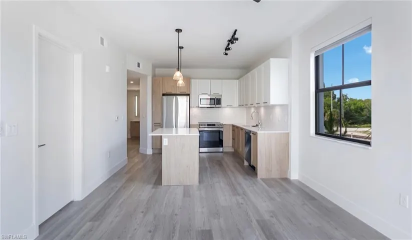 Kitchen with visible vents, light wood-type flooring, a sink, and appliances with stainless steel finishes