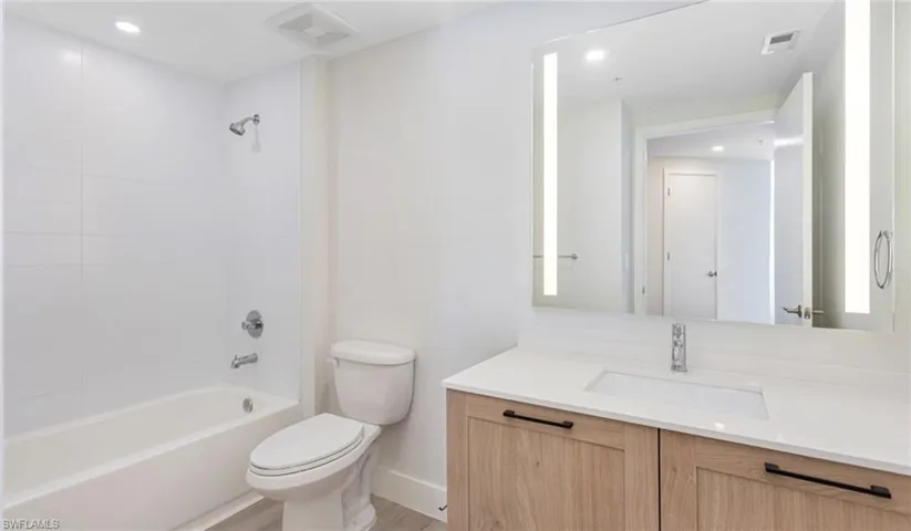 Full bathroom featuring vanity, baseboards,  shower combination, toilet, and visible vents