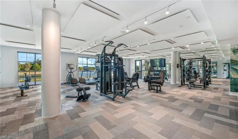 Workout area featuring carpet flooring, ornate columns, baseboards, and track lighting