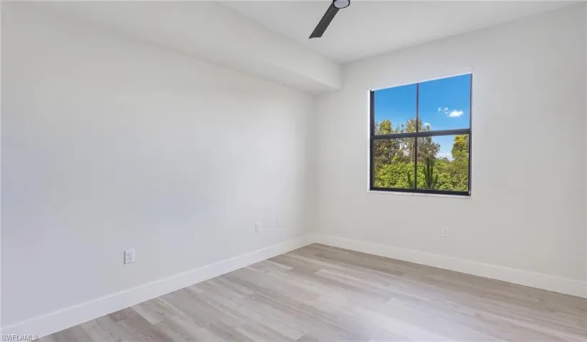 Spare room featuring light wood finished floors, baseboards, and a ceiling fan