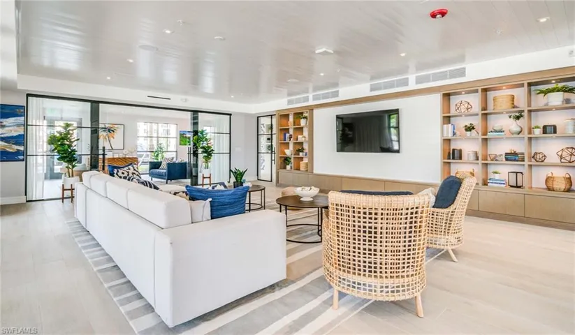 Living room featuring visible vents, built in shelves, and light wood-type flooring
