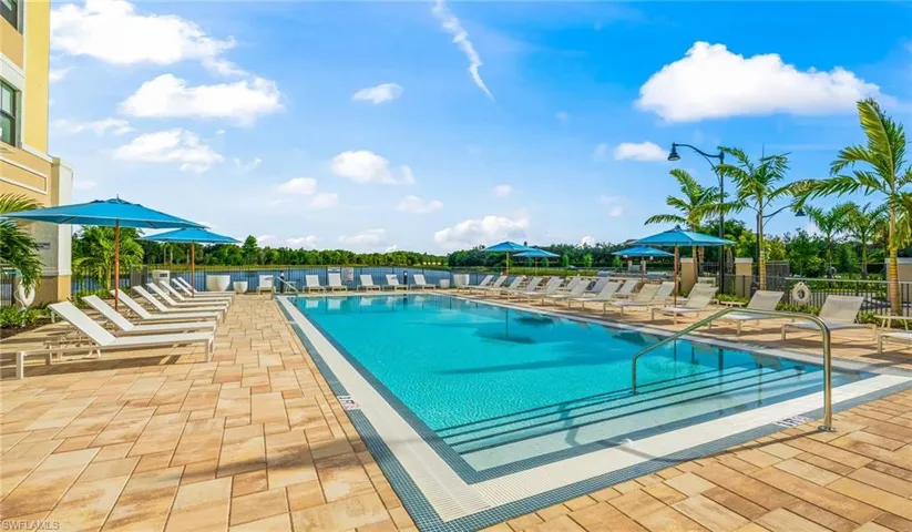 Community pool featuring a patio area and fence