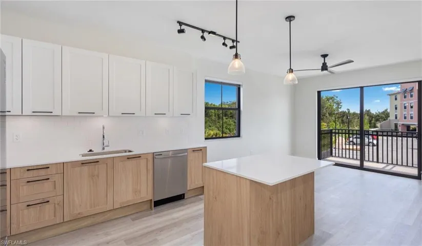 Kitchen featuring a sink, stainless steel dishwasher, a wealth of natural light, and decorative backsplash