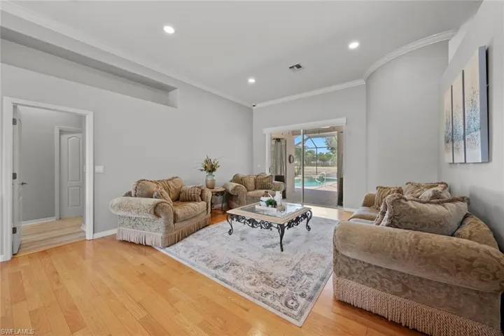 Living room with crown molding and light hardwood / wood-style flooring