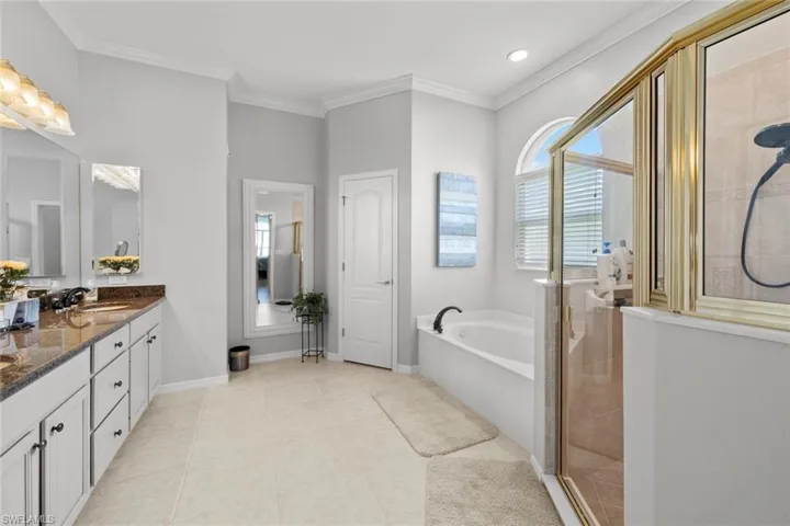Bathroom featuring independent shower and bath, oversized vanity, ornamental molding, and tile floors