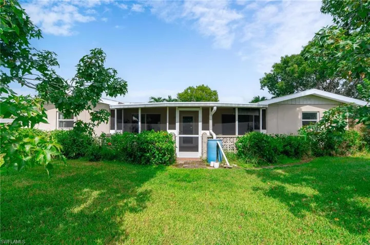 View of front of home featuring a sunroom and a front lawn