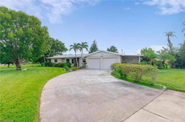 Single story home featuring a garage and a front yard