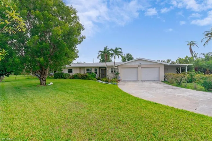 Ranch-style home featuring a garage and a front lawn