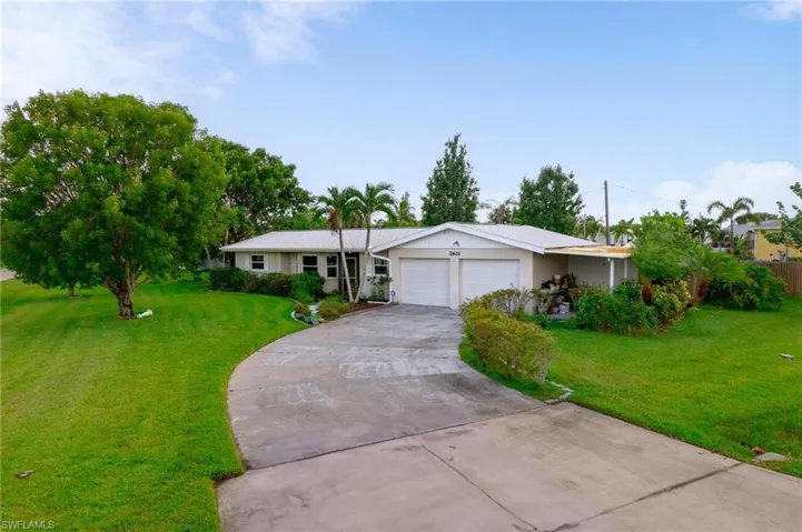 Ranch-style house featuring a garage and a front yard