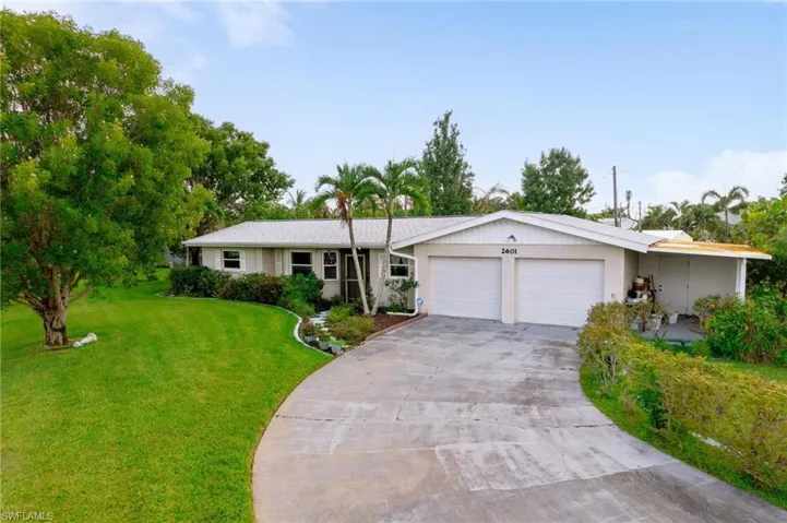 Ranch-style house featuring a garage and a front lawn