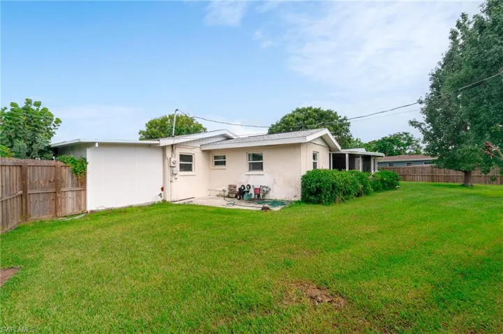 Rear view of property with a yard