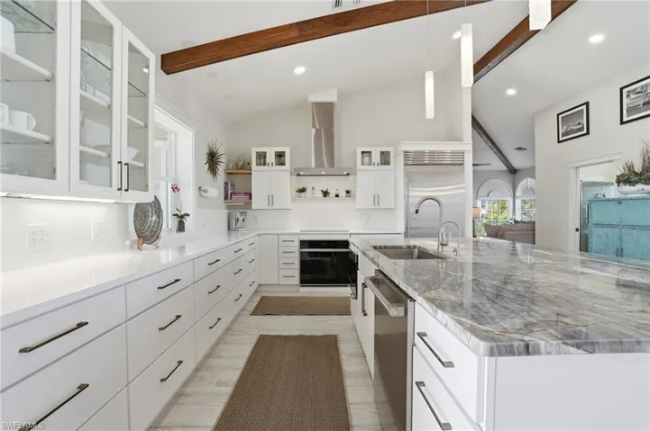 Kitchen with glass insert cabinets, white cabinets, hanging light fixtures, open shelves, and recessed lighting - Virtually Edited Image