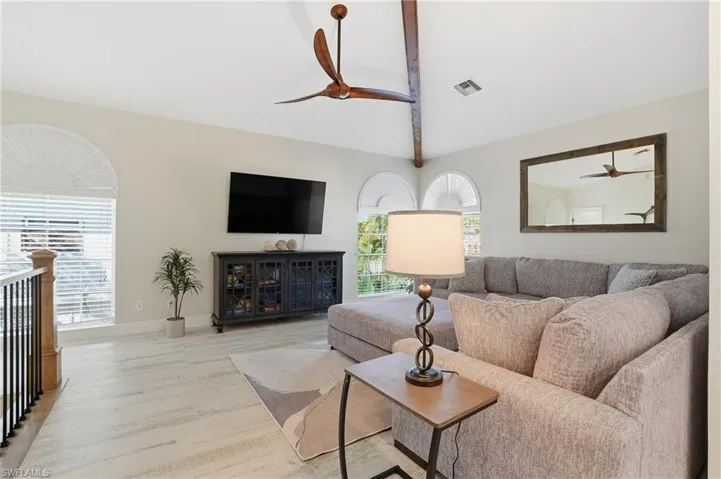 Living area featuring ceiling fan and wood finished floors - Virtually Edited Image