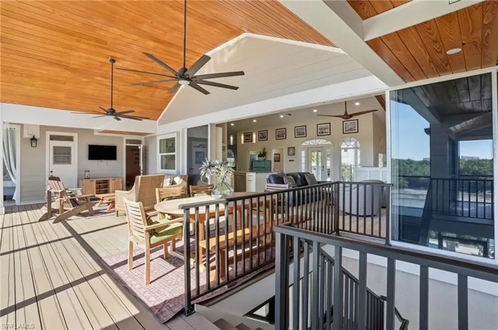 Wooden deck featuring outdoor dining space and ceiling fan - Virtually Edited Image