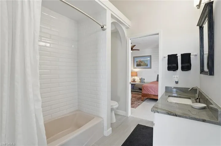 Ensuite bathroom with vanity, shower / bath combo, and a ceiling fan - Virtually Edited Image