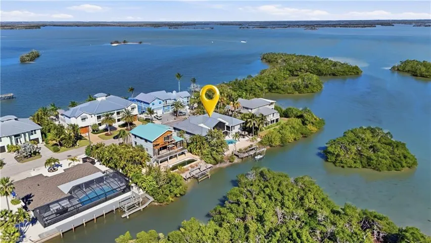 Aerial view of property's location featuring a nearby body of water and nearby suburban area - Virtually Edited Image
