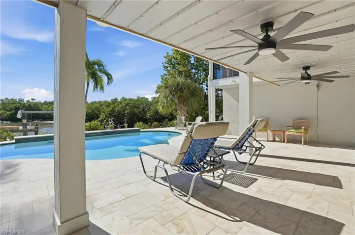 Swimming pool with a patio and view of wooded area - Virtually Edited Image